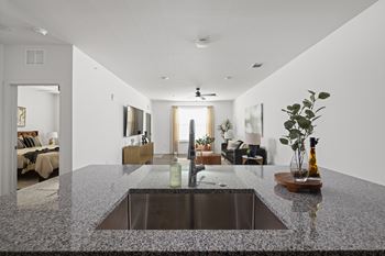 A modern kitchen with a granite countertop and a sink.